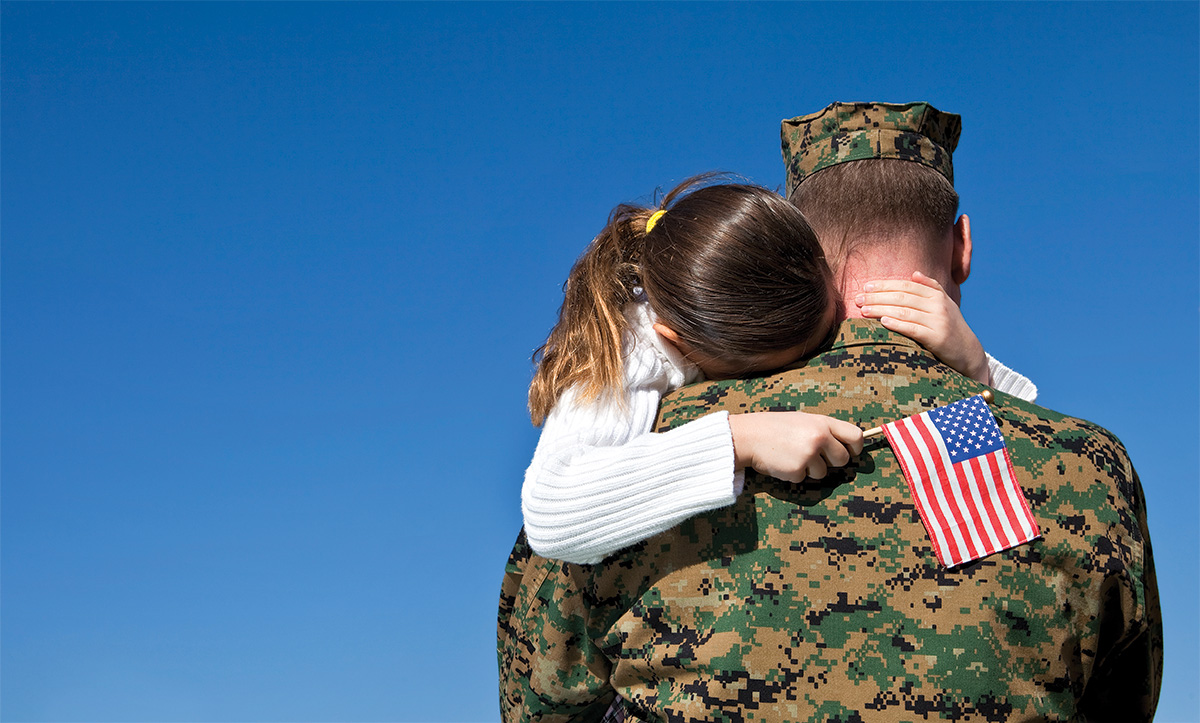 Soldier hugging young girl
