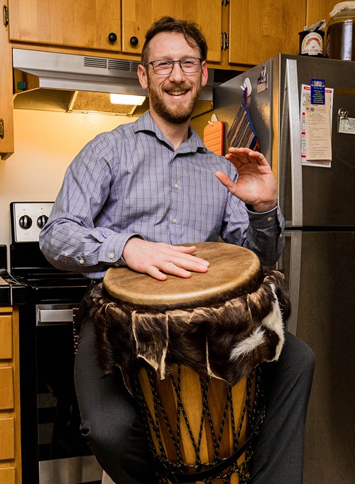 Cody Mills Playing A Drum In His Home