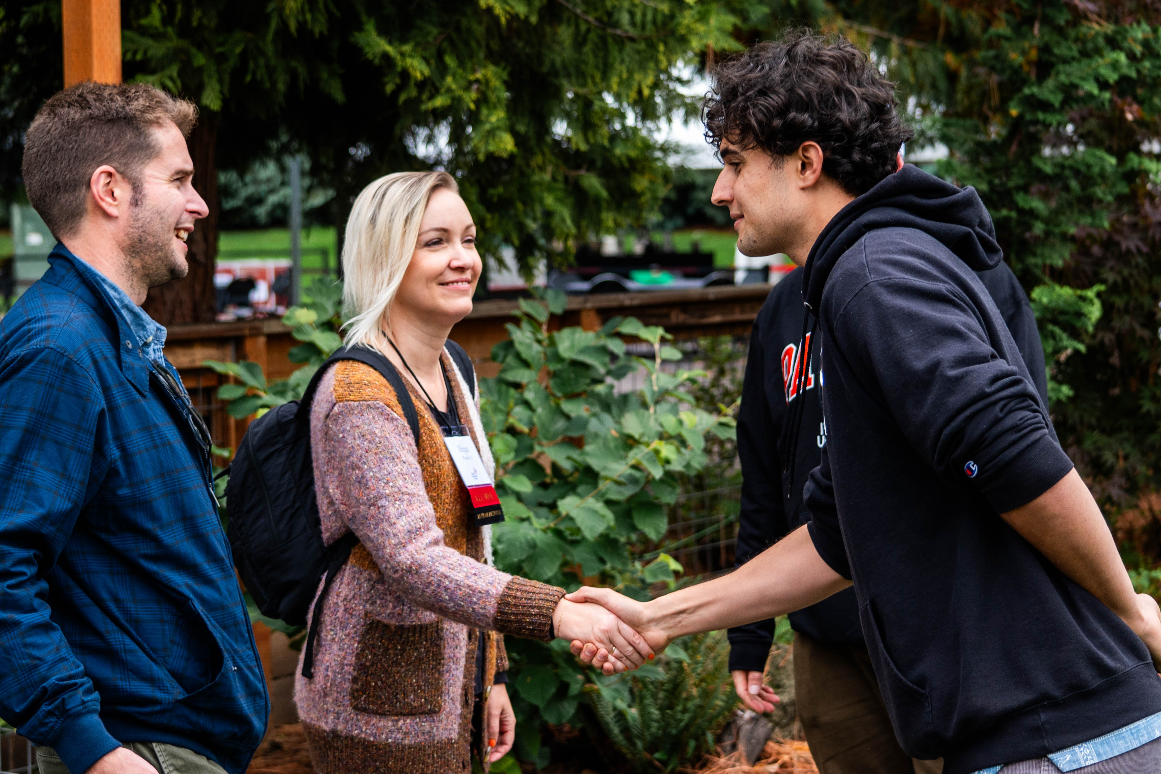 A current Pacific undergraduate students greets two alumni during Homecoming weekend.