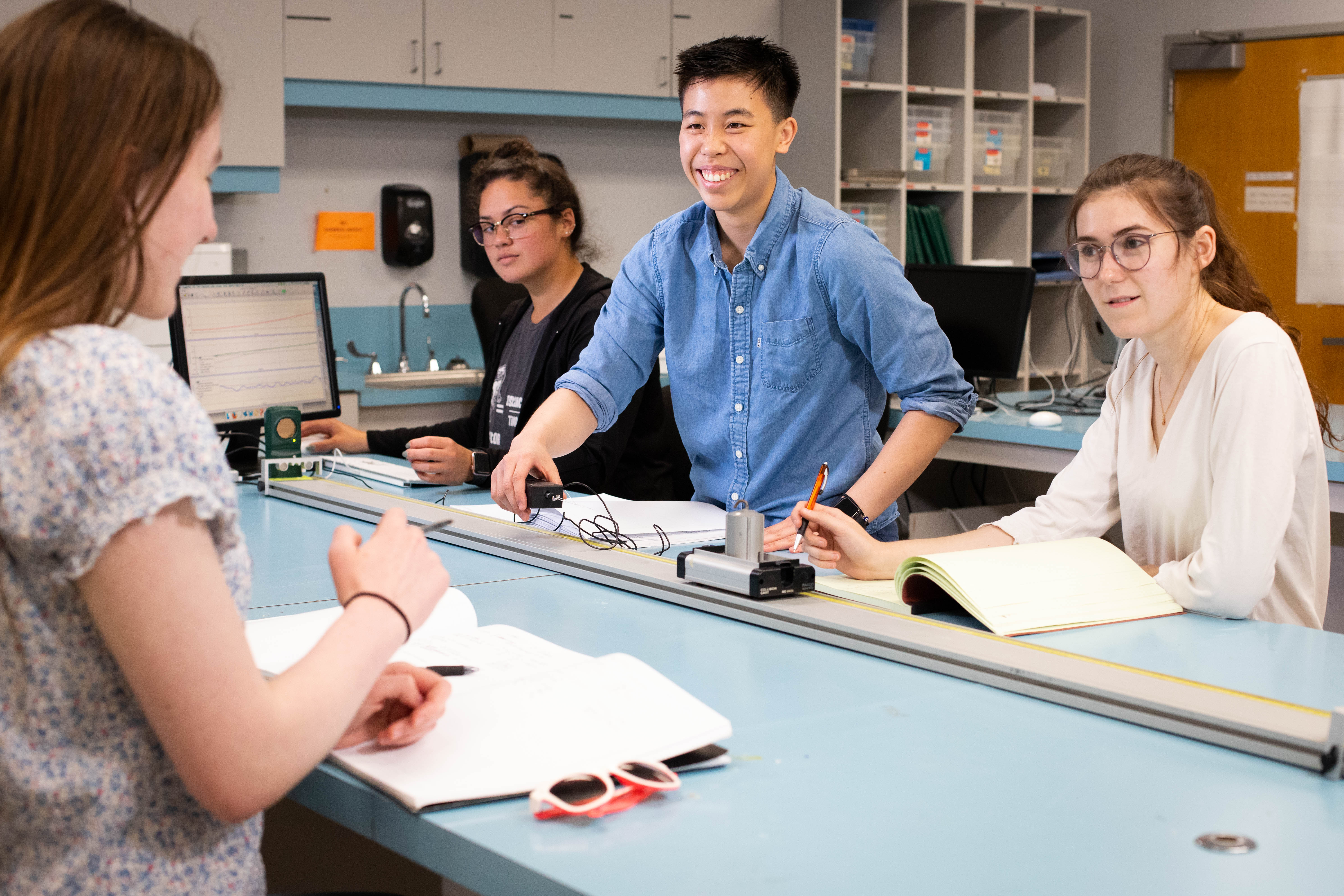 A group of undergraduate students discuss coursework in one of Pacific's engineering physics labs.