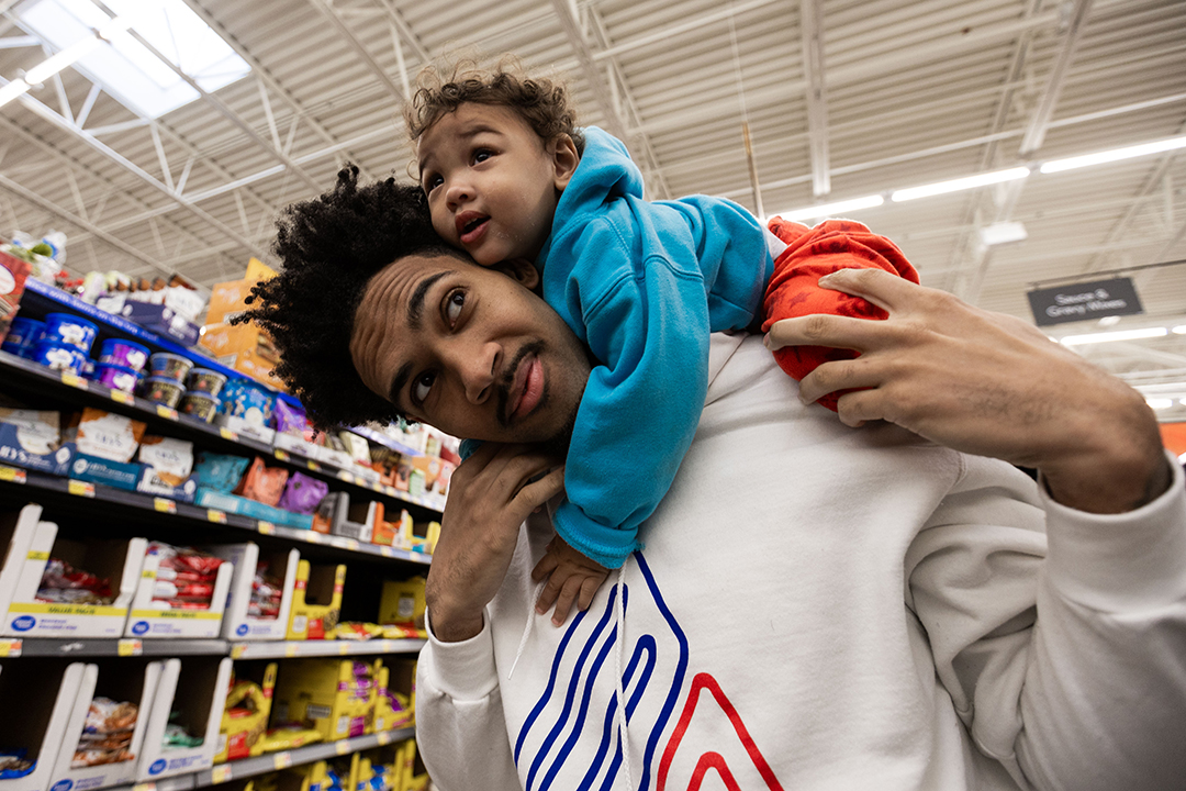 Devin Fortune '25 carries his son, Rocket, through a local grocery store