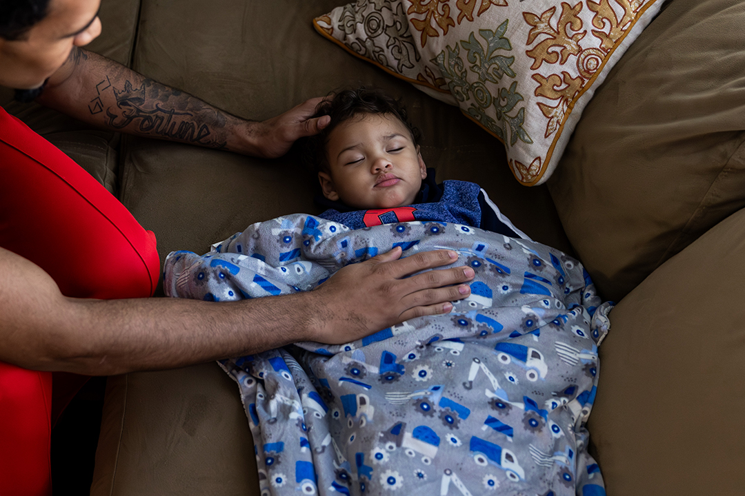 Devin Fortune '25 cuddles his sleeping son, Rocket