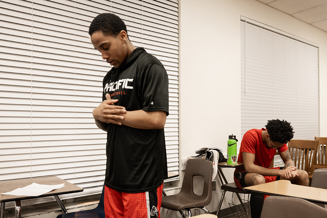 Devin Fortune '25, right, and Kemari Cooper '25, left, pray individually before a basketball game