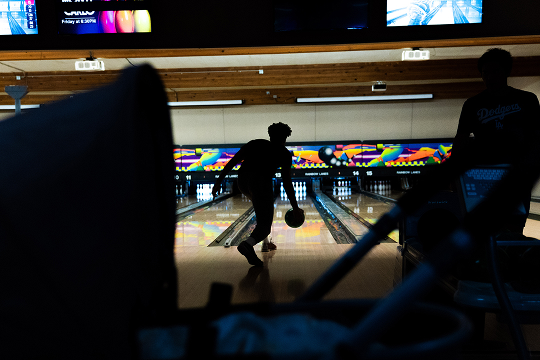 Devin lines up a shot while bowling with his family at Rainbow Lanes during a student event