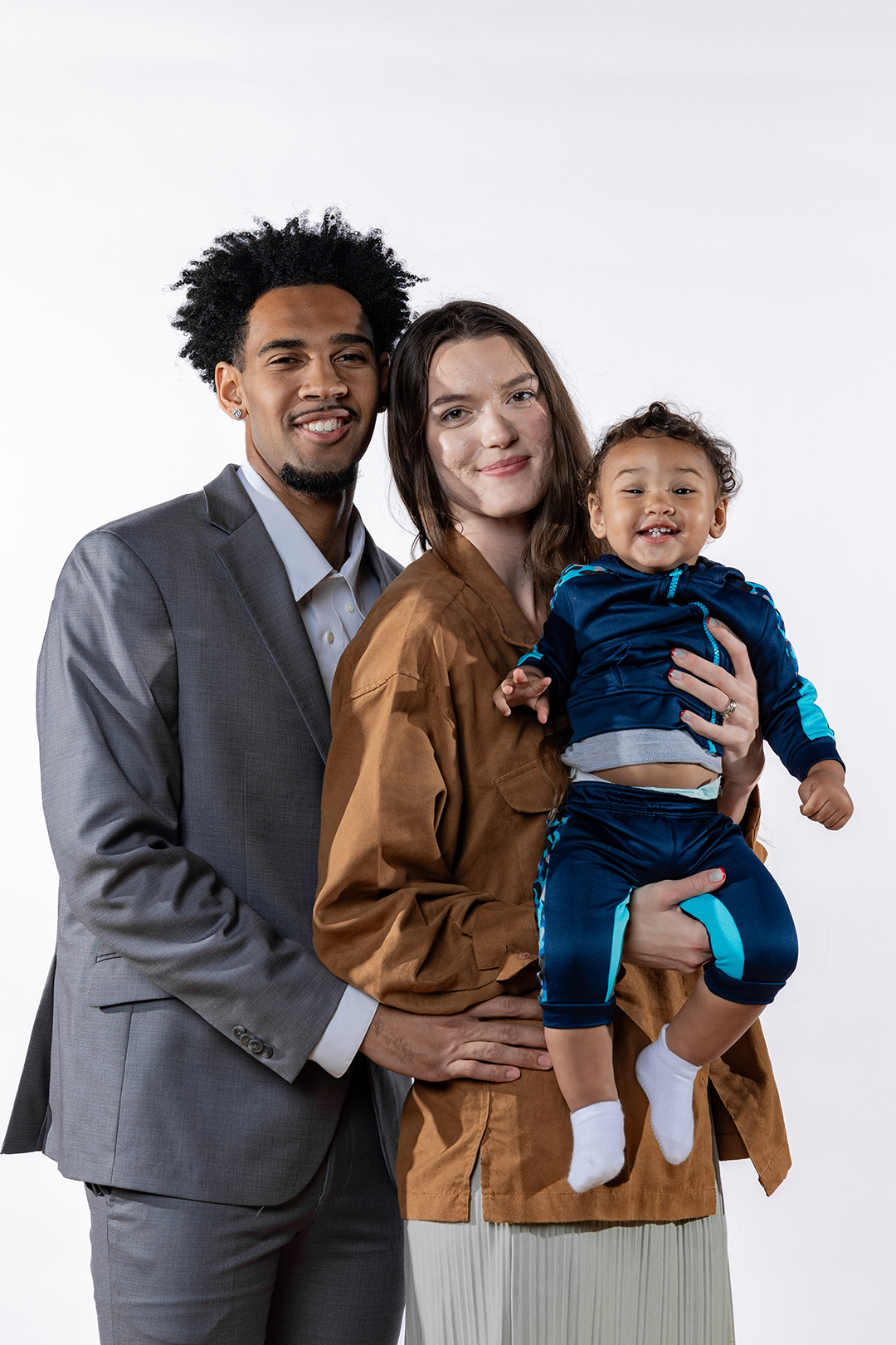 Family portrait of Devin Fortune '25, his wife Kristina, and their son Rocket