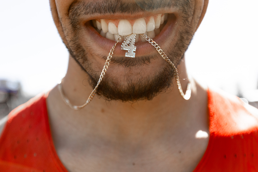 Jay Fordham '25 — known to friends as Jay4 — holds his No. 4 necklace in his teeth