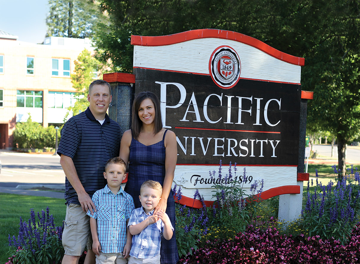 DeBois Family posing in front of Pacific University Signage