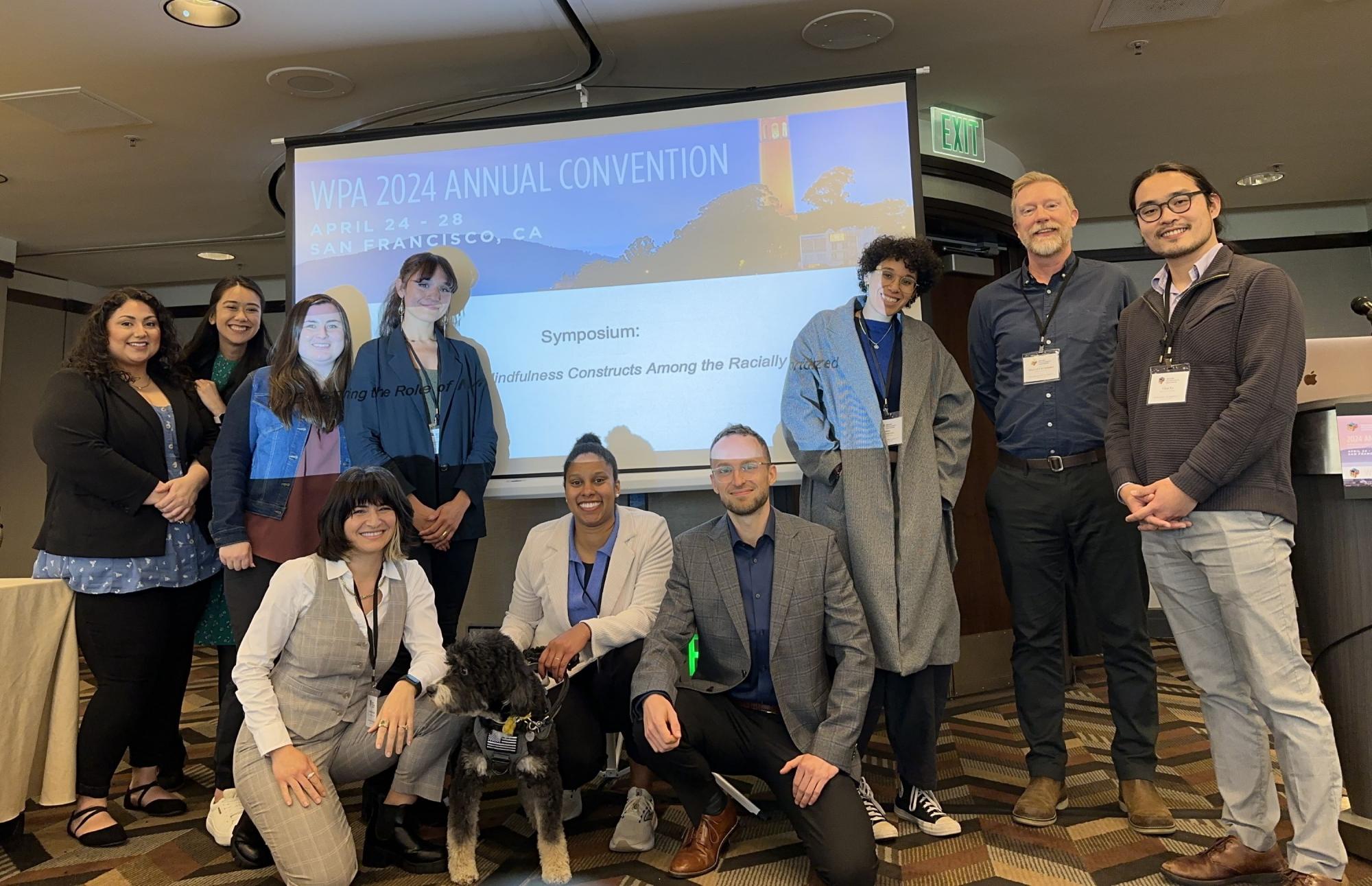 People standing in front of board that reads "WPA 2024 Annual Convention"