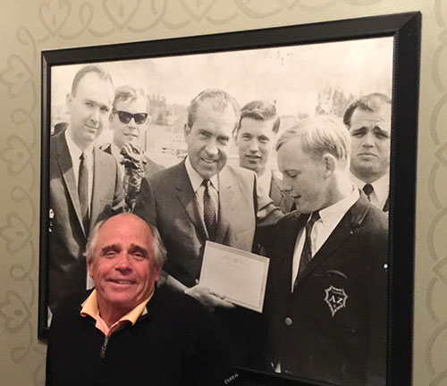 Jim Fitzgerald '68 In Front Of Picture Of Richard Nixon & Boxer.