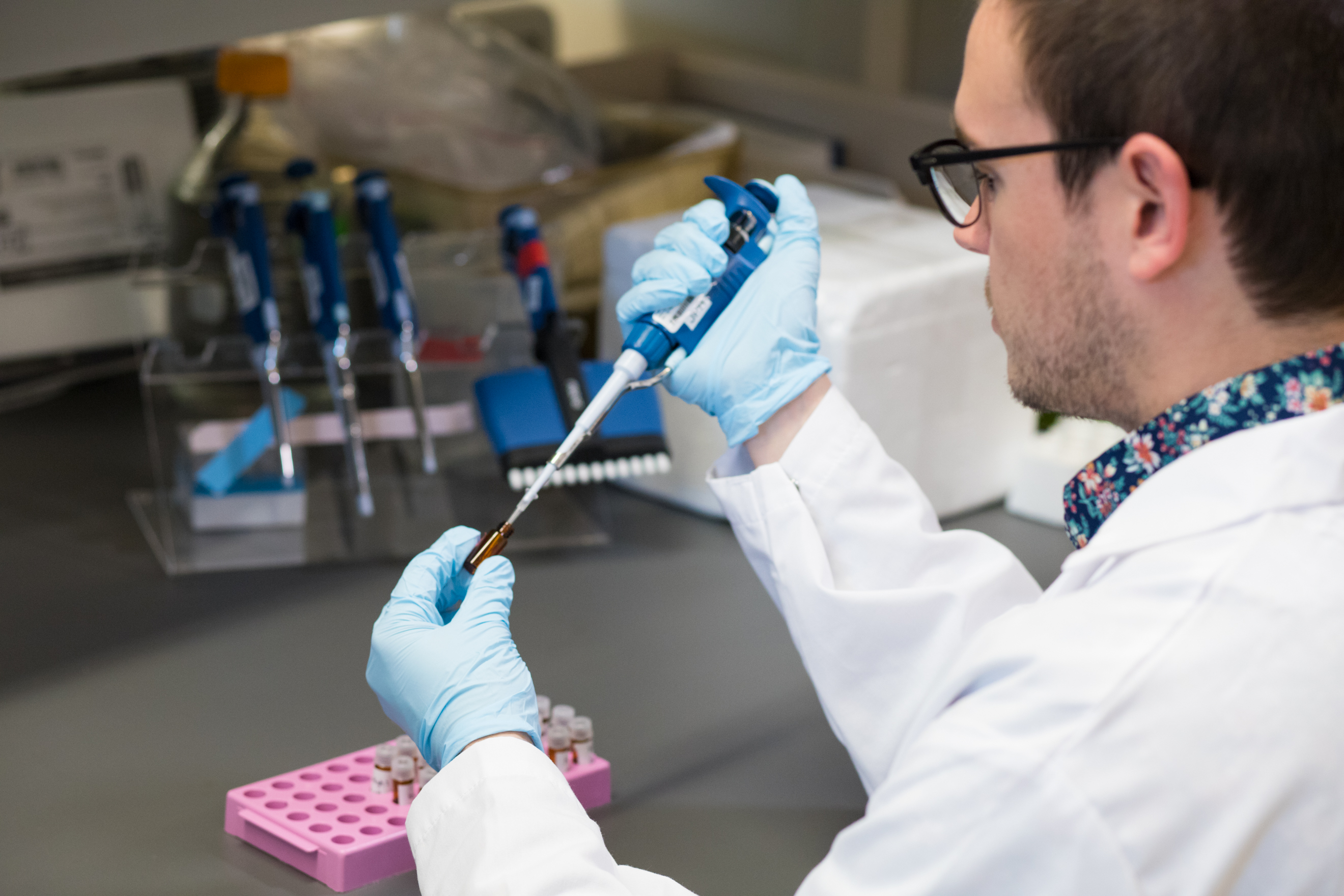 A pharmacy student uses a pipet in the campus pharmacy lab.