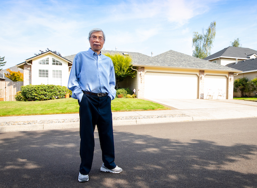 Tim Tran in front of a house