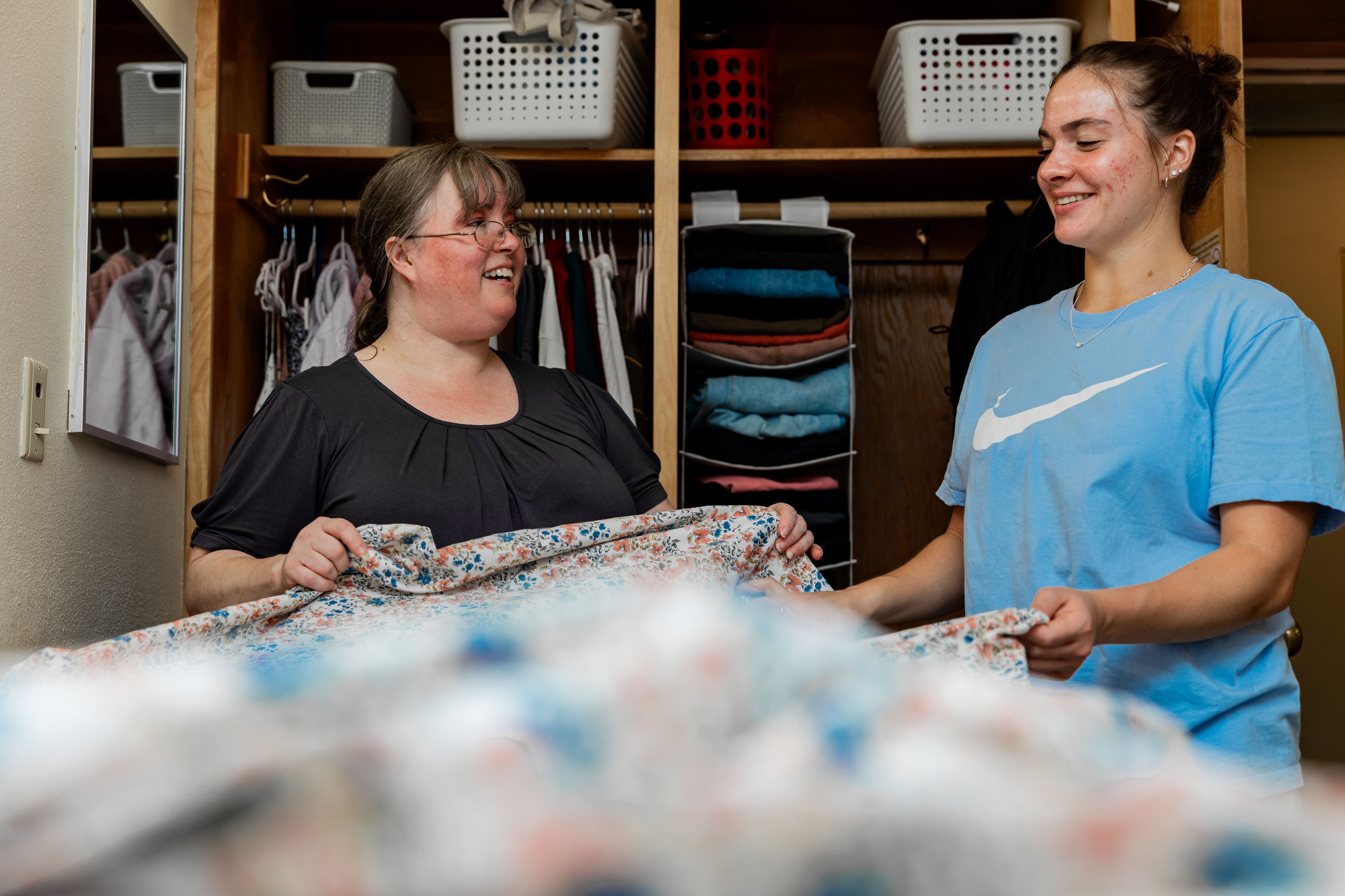 A student is helped by the mother as they move into their dorm during new student orientation.