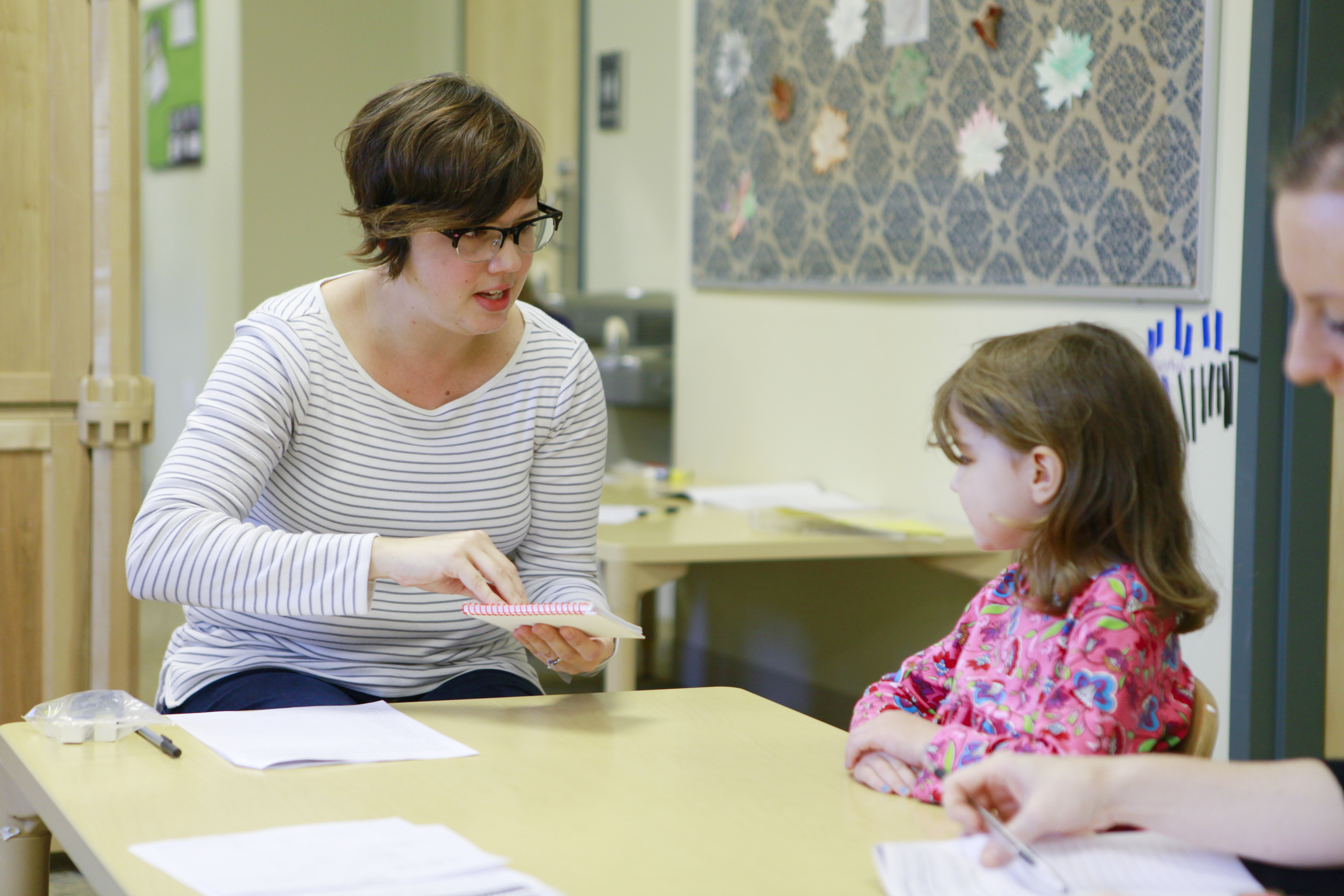 A speech therapy student demonstrates a vocalization to a child. 
