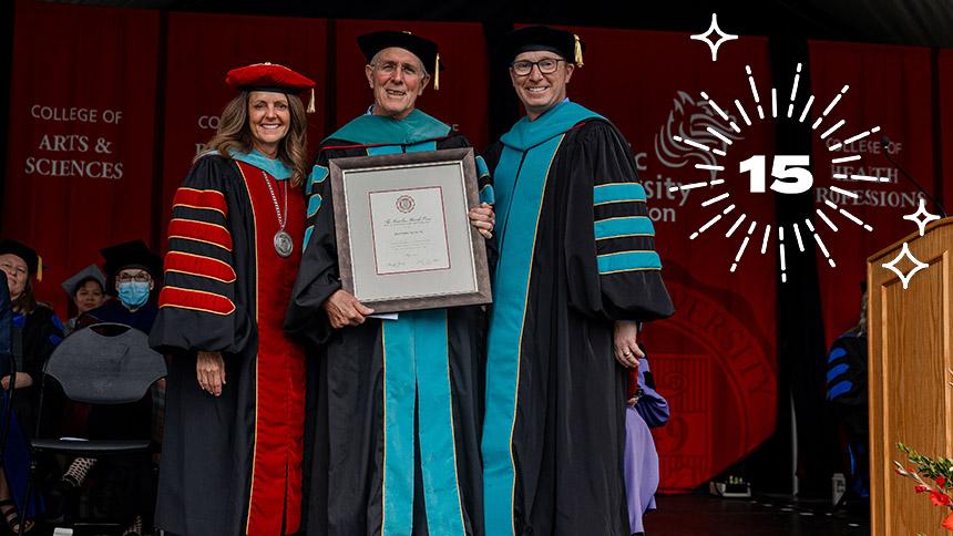 Scott Pike '68, OD '70 on stage at Commencement with Jenny Coyle and Fraser Horn