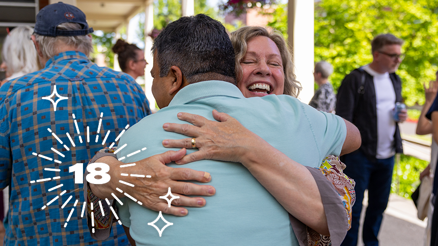 MFA alumni and friends hug at the 20th anniversary celebration