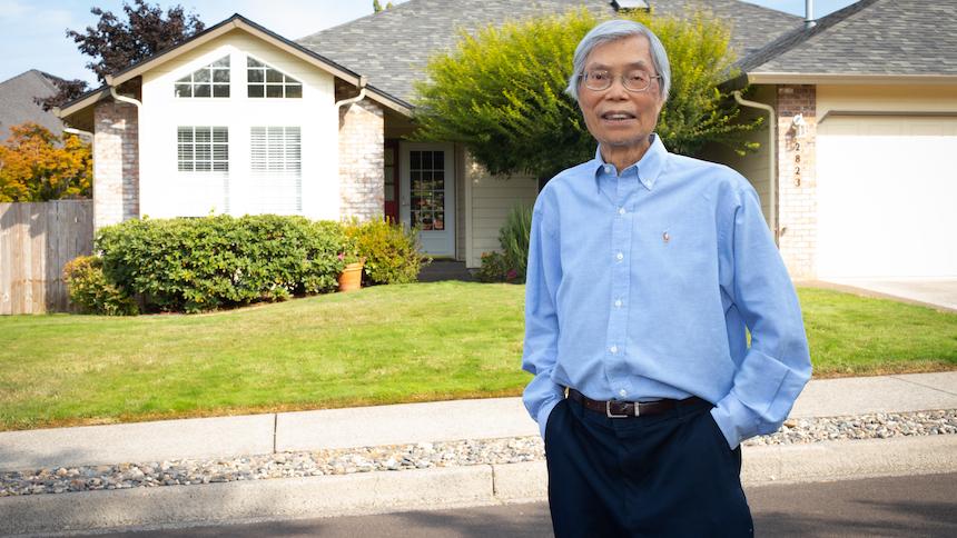 Tim Tran in front of a house