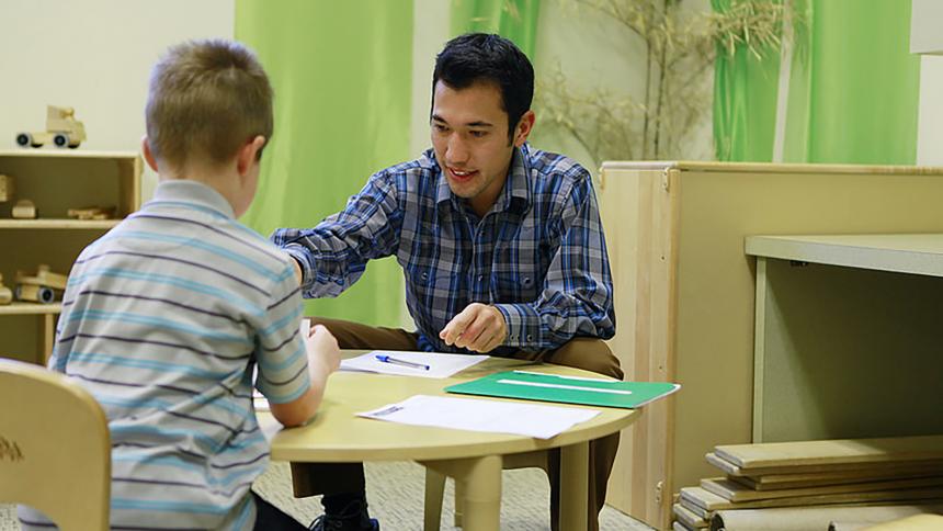 A communication sciences and disorders student works with a child in a classroom