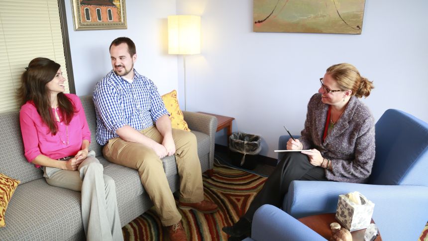 three people talking on sofas