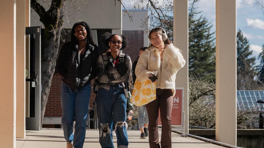 Three students walk through Pacific's Forest Grove campus.