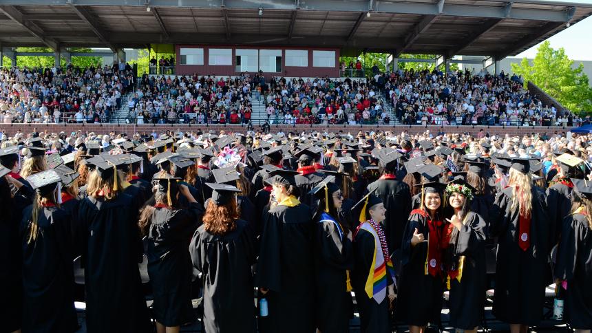 Graduates wave to supporters in the crowd at Commencement 2023