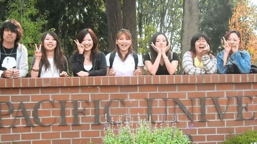 International Students pose in front of Pacific University sign