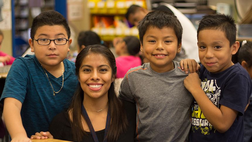 Student teacher posing with 3 young schoolchildren (boys)