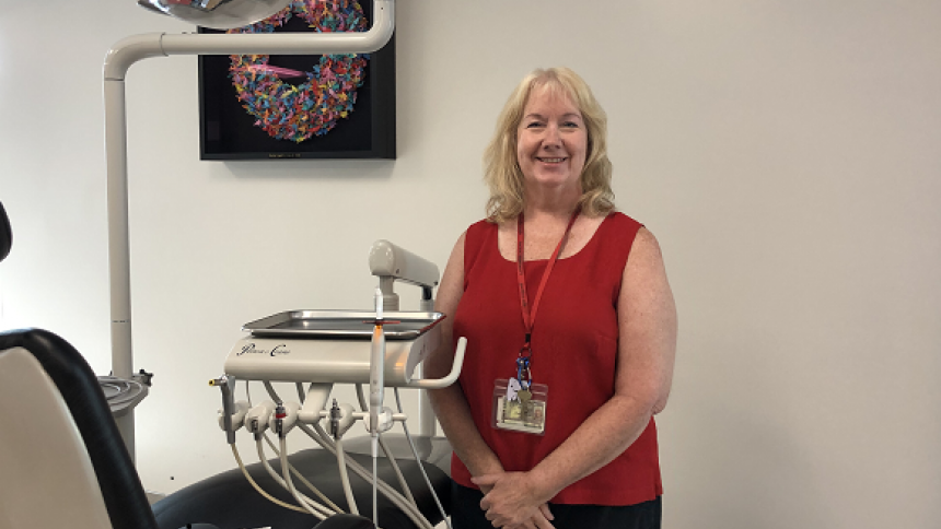 Dental Hygiene Studies founding director Lisa Rowley stands in program's clinic next to a dental chair