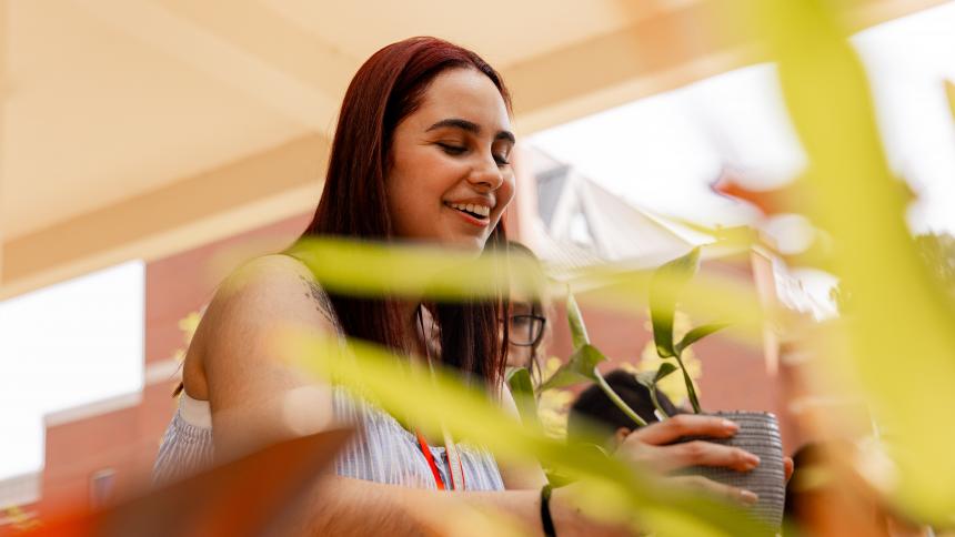 A freshman student from Pacific University repots a potted plant during the Adventures Without Limits program.