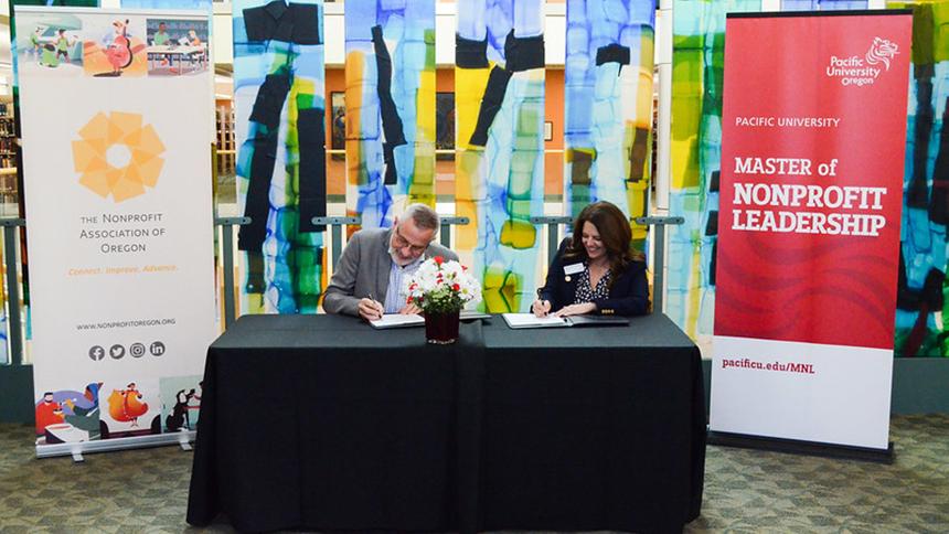 Nonprofit Association of Oregon Executive Director Jim White and Pacific University President Jenny Coyle sign a partnership agreement at a celebration Oct. 11, 2022.