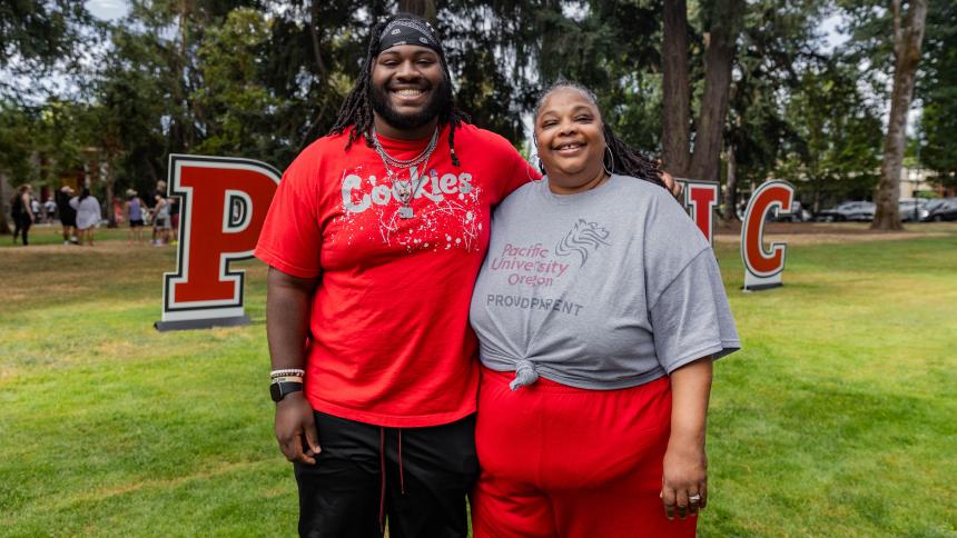 A parents poses with their adult child during move-in day at Pacific's Forest Grove campus.