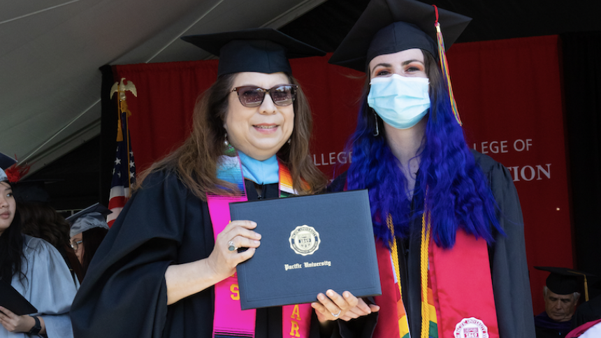 Stuart-Shuman receives diploma on stage with Narce Rodriguez