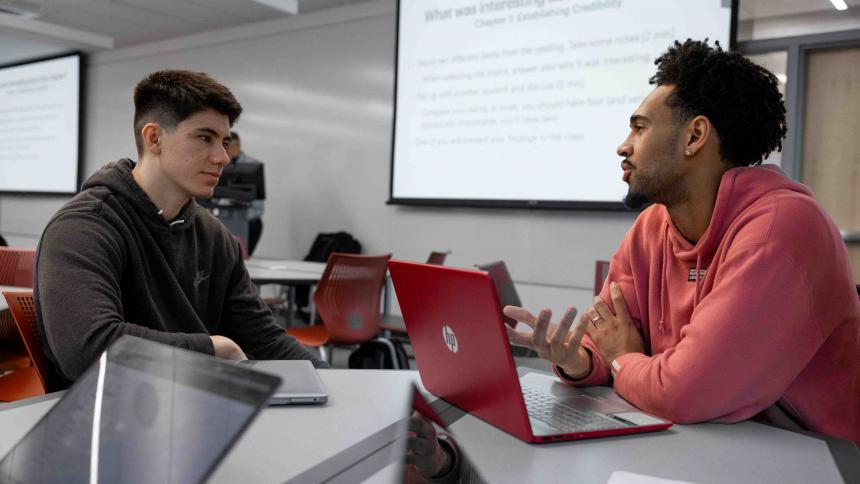 Two students discuss a question during class.