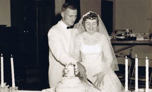 Couple cutting wedding cake 