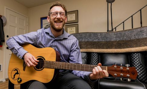 Cody Mills Playing The Guitar In His Home