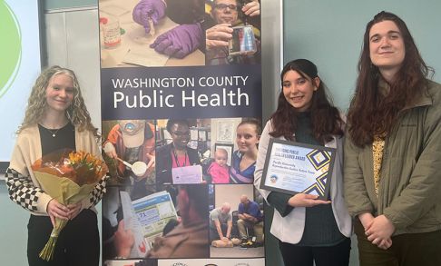 Members of the Reproductive Justice Action Team Standing Next To Washington County Public Health Sign