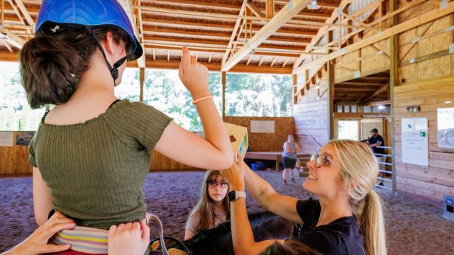 A Pacific alumna uses horses to provide occupational therapy to a child