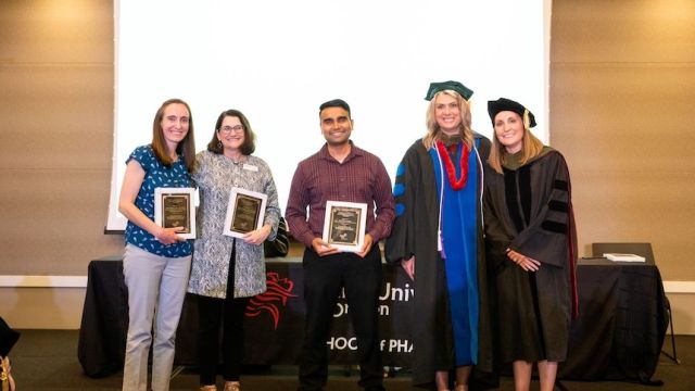 People standing, holding certificates