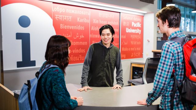 Students talk at an information desk at Pacific University