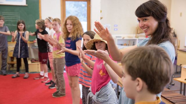 teacher with students clapping