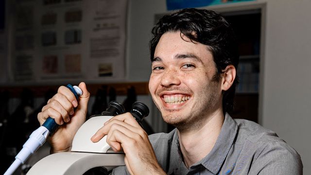 Duncan Anderson '24 Posing With Syringe and Microscope