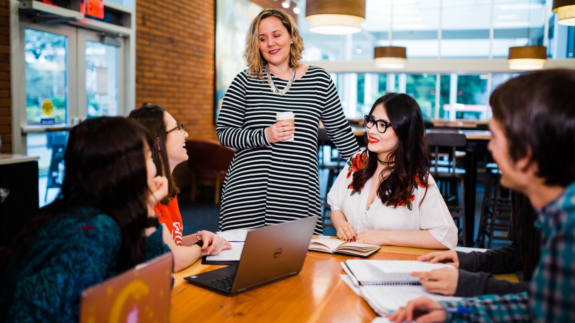 students and teacher talking at a table